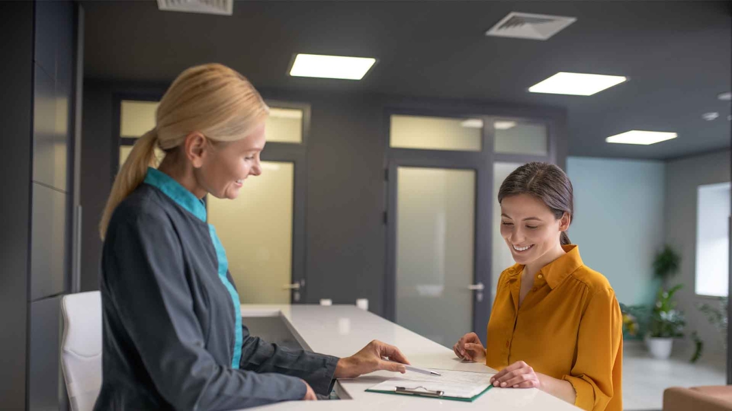 Two women reviewing loan documents at a bank—illustrating the process of applying for loans in Germany for foreigners.