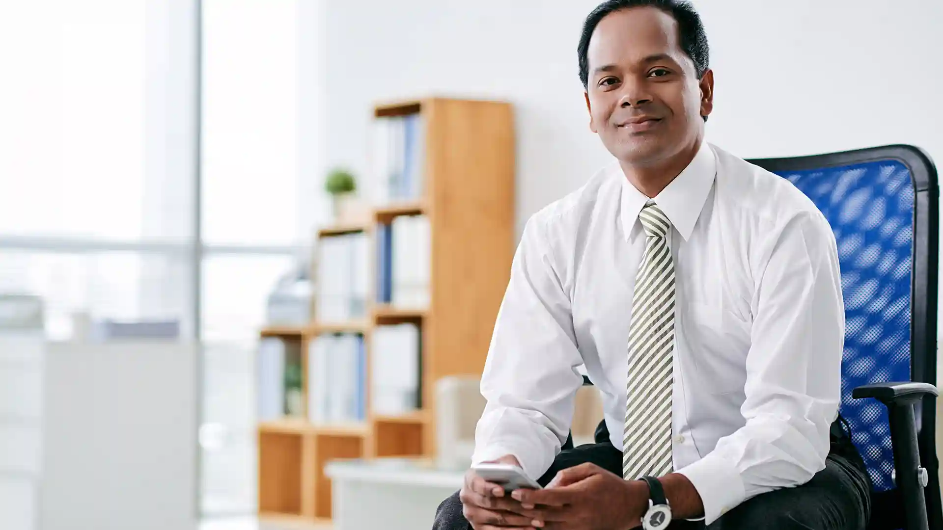 An indian businessman holding phone in hand and planning to Move to Germany from India
