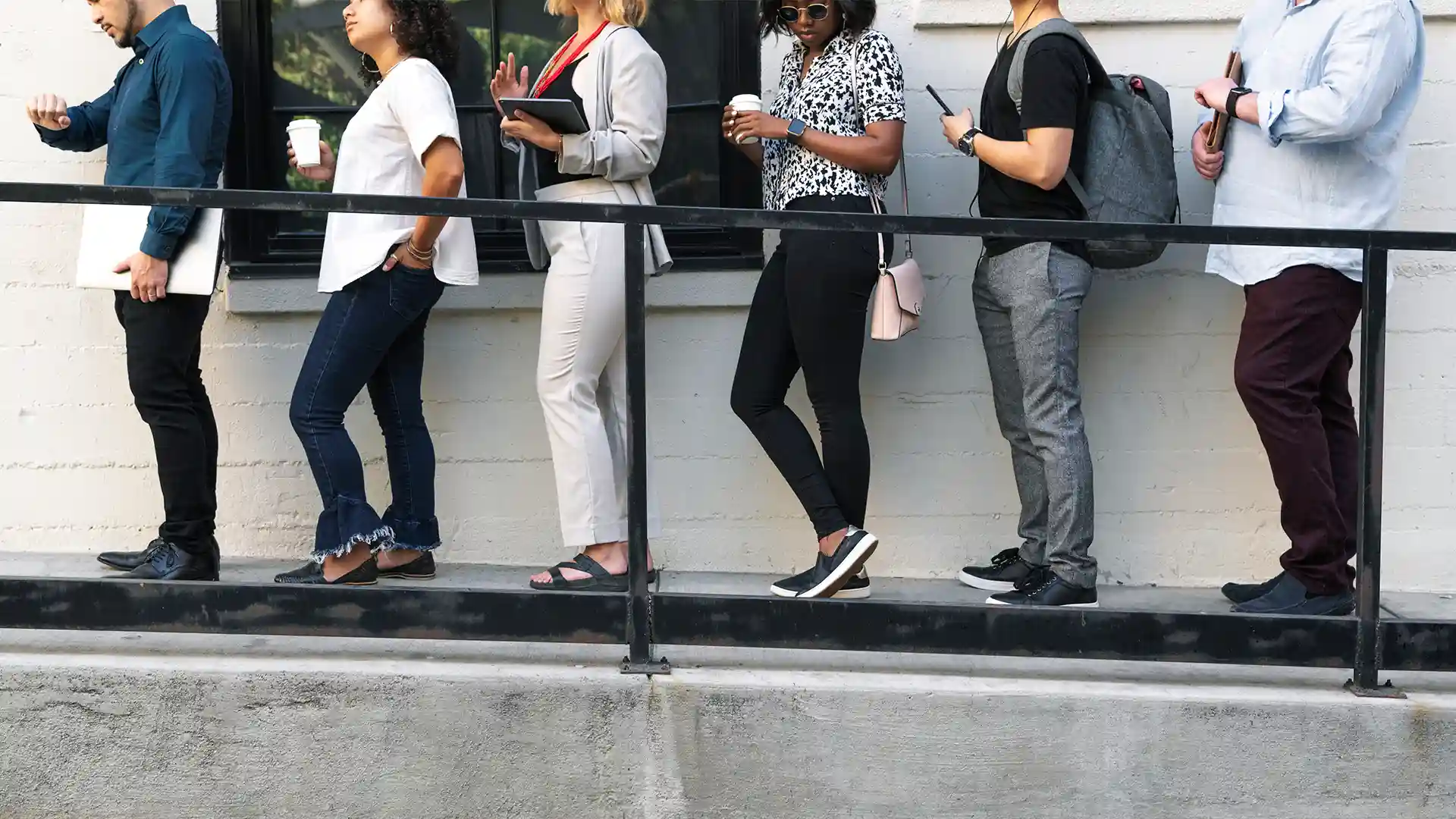 People waiting in a long line outside the Berlin Immigration Office, showing typical wait times for visa and residence services.
