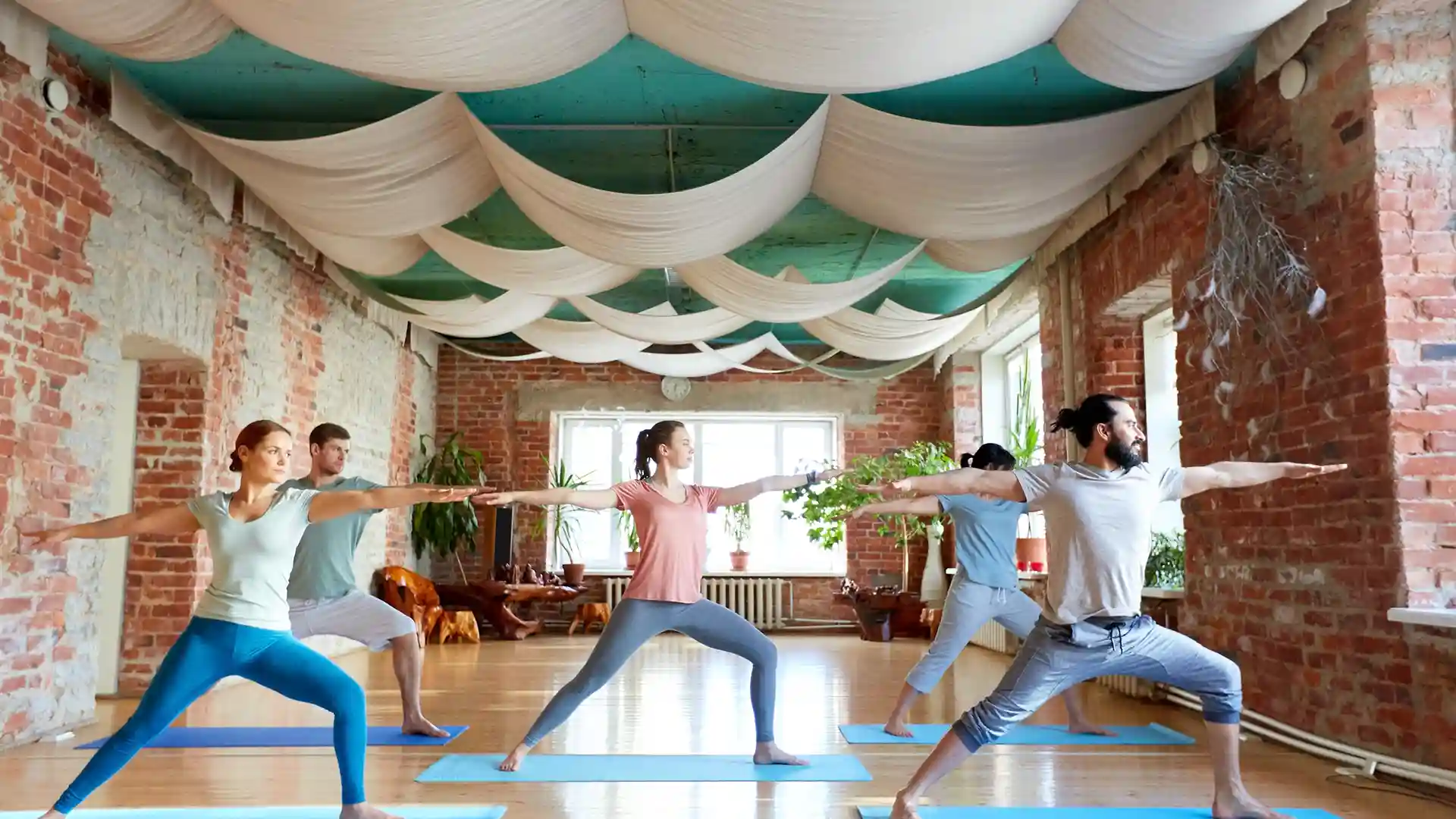 People practicing yoga in a bright Berlin studio, representing the vibrant and diverse yoga community at the best yoga studios in Berlin.