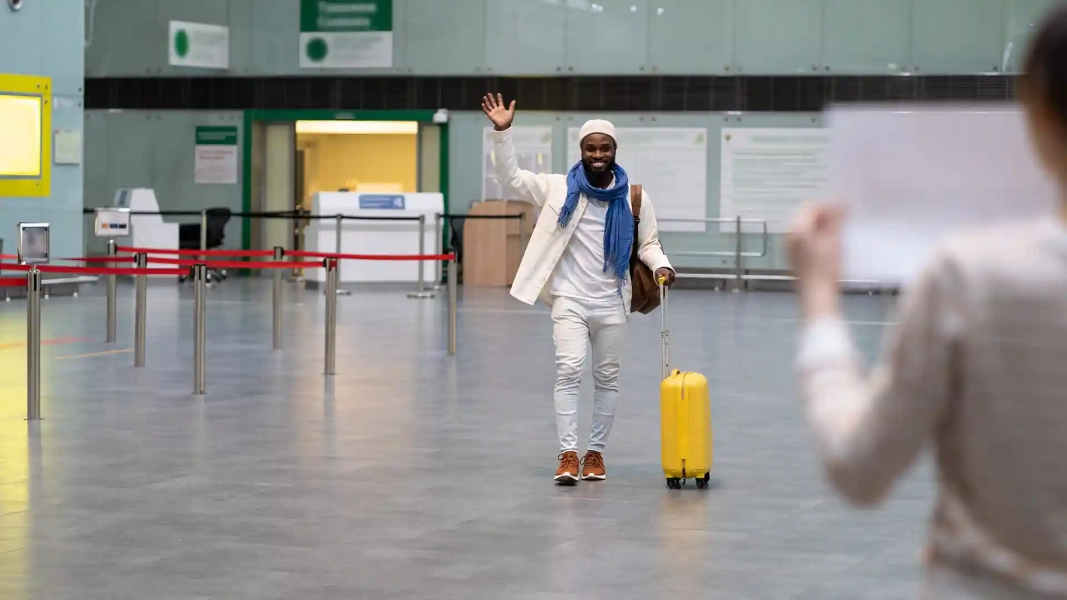 Man arriving at the airport with luggage, symbolizing relocating to Germany.