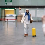 Man arriving at the airport with luggage, symbolizing relocating to Germany.