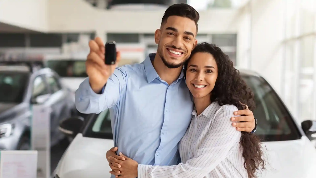 Happy Middle Eastern couple with their new car, celebrating after successfully using an eVB number in Germany to complete the vehicle registration.