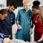 International nursing students practicing medical training on a dummy — how to apply for nursing Ausbildung in Germany
