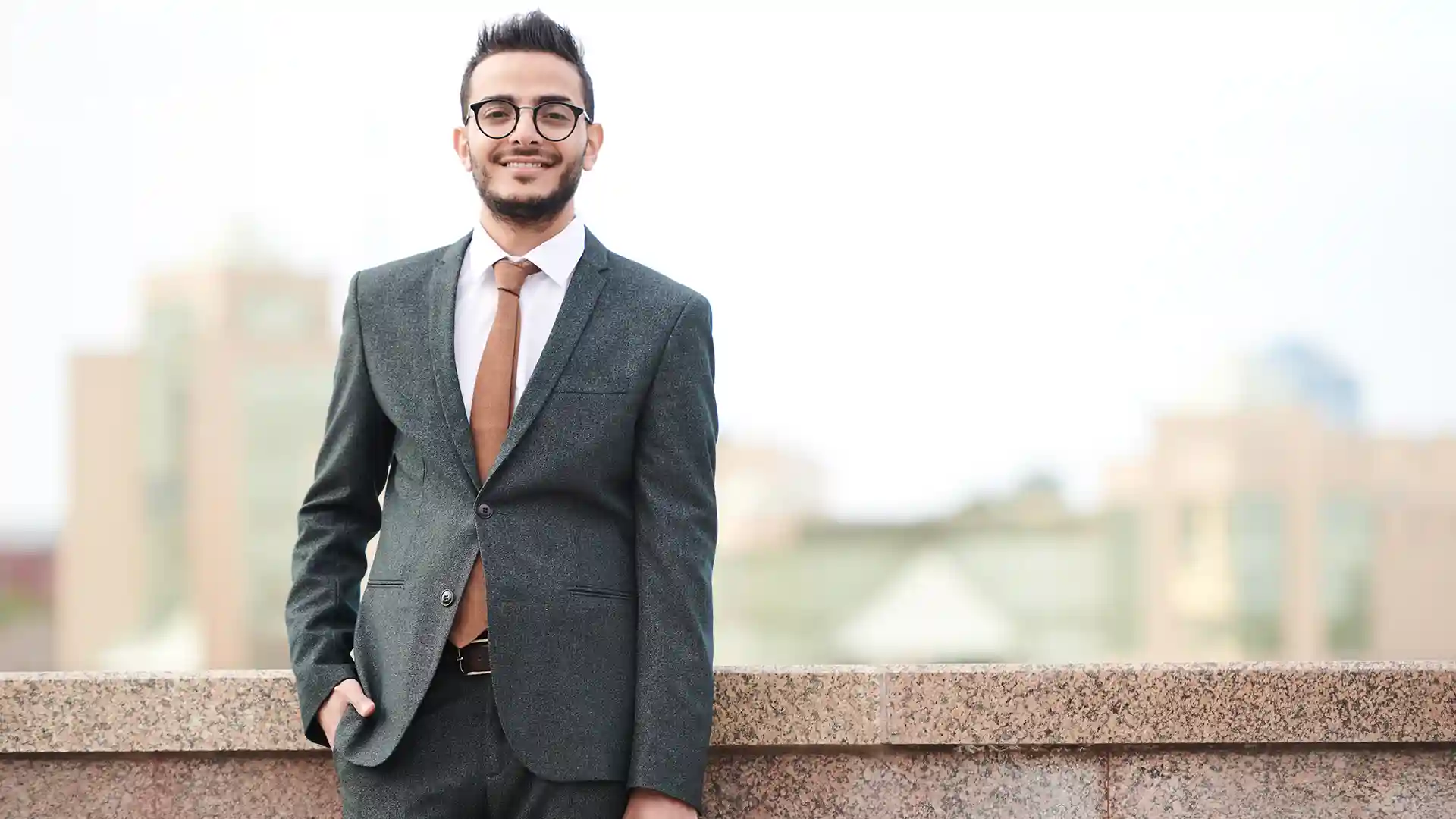 Confident young man in a suit holding a briefcase, representing How to Get a Job in Germany from Morocco as a skilled professional.