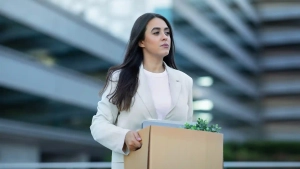 Woman carrying a box after job loss, representing the topic How to Stay in Germany After Losing Your Job in a professional setting.
