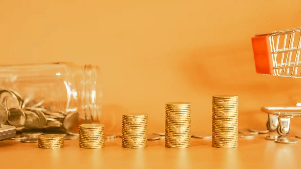 Coin stacks growing beside a tipped jar and shopping cart, visually representing the Average Salary vs Cost of Living in Germany and how expenses increase with income.