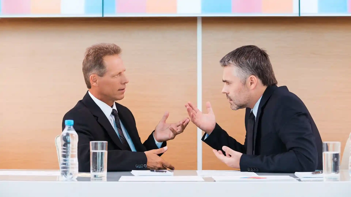 Two businessmen in a heated discussion showing how the German Communication Style Rude dynamic can escalate professional conversations.
