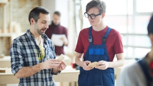 Vocational trainer teaching a young apprentice during a carpentry session – Apply for Ausbildung in Germany From Abroad.
