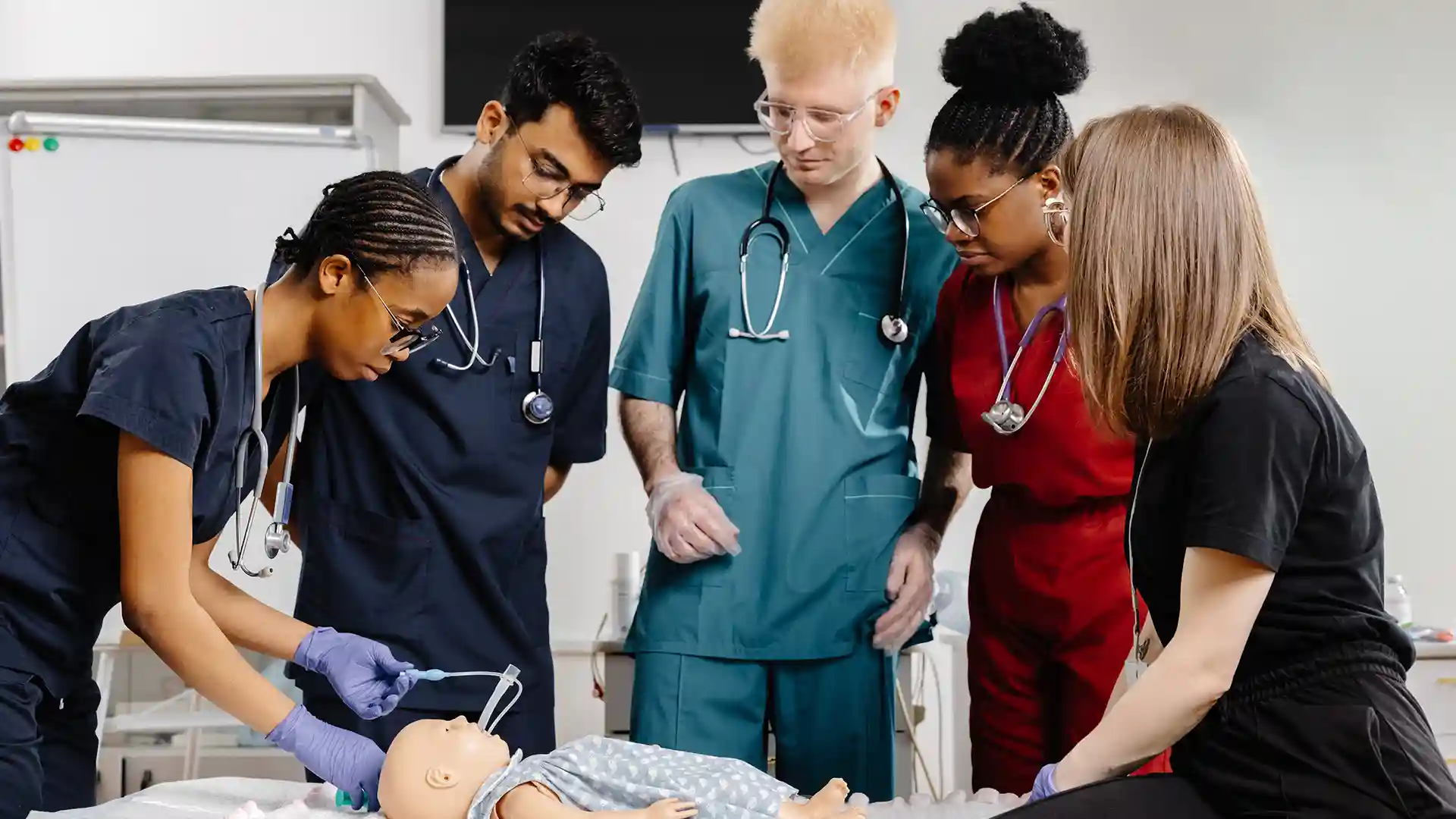 International nursing students practicing medical training on a dummy — how to apply for nursing Ausbildung in Germany