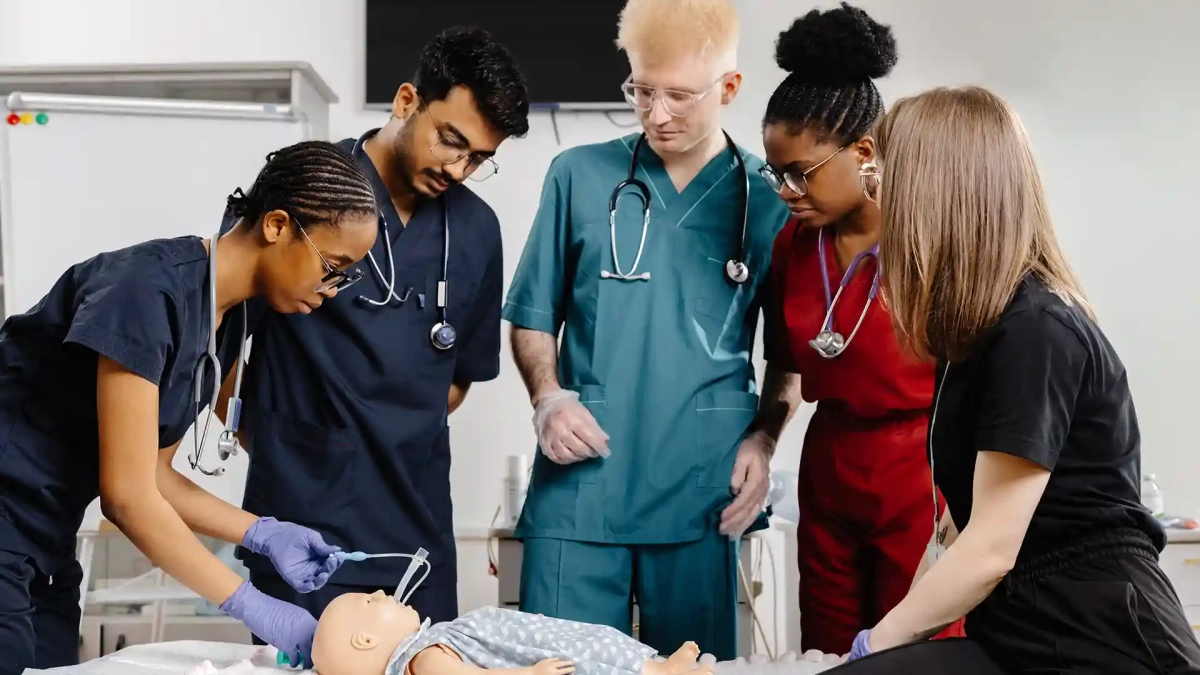 International nursing students practicing medical training on a dummy — how to apply for nursing Ausbildung in Germany